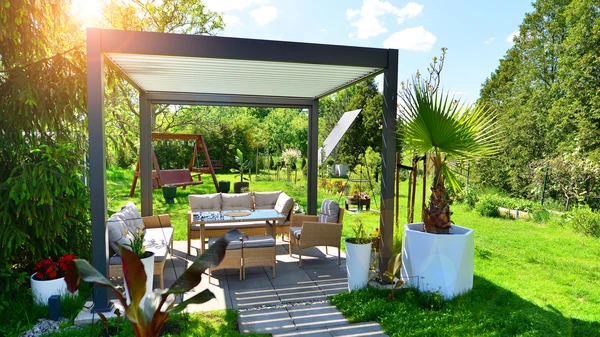 Terrasse extérieure résidentielle avec pergola métallique grise et filet de protection anti-chute